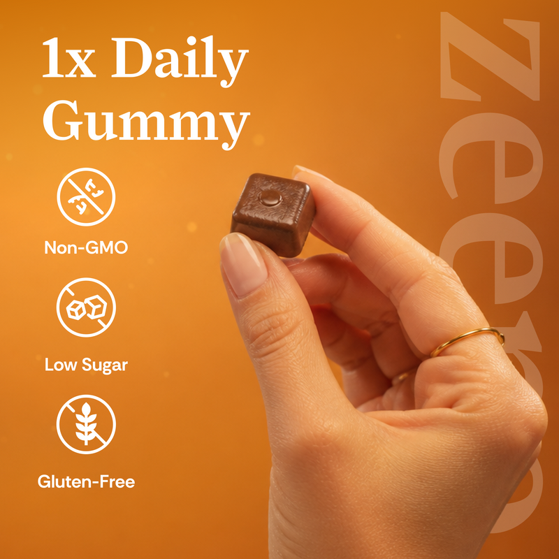 A hand holds a single square dark red gummy cube against an orange background with text reading '1x Daily Gummy' and icons for Non-GMO, Low Sugar, and Gluten-Free.